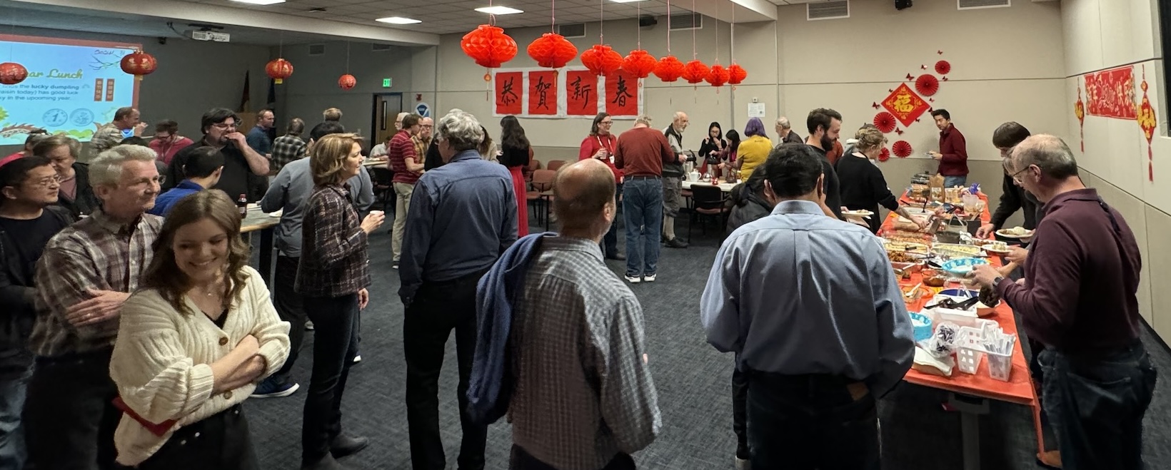 Chinese New Year's Eve celebration with GSL staff, a potluck, and red and gold decorations in the conference room.